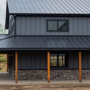 Maison moderne avec couverture métallique et piliers bois.